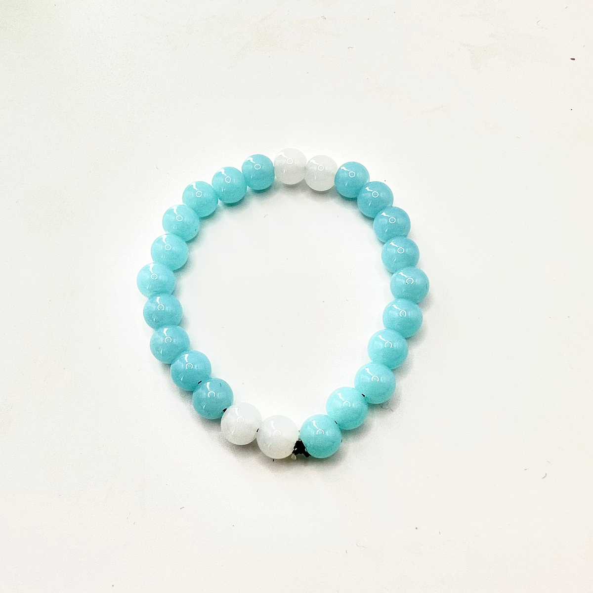Beaded bracelet with blue and white beads on a white background